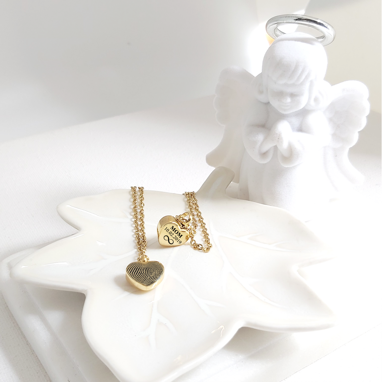 Personalized thumbprint heart urn necklace for human ashes.