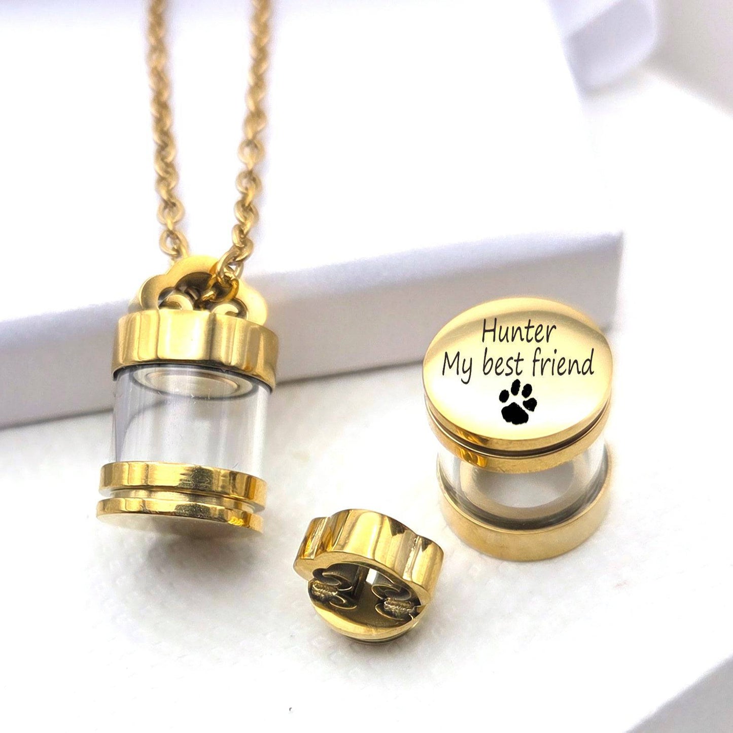 Gold necklace with a clear cylindrical pendant engraved with 'Hunter My best friend' and a paw print on a white background.