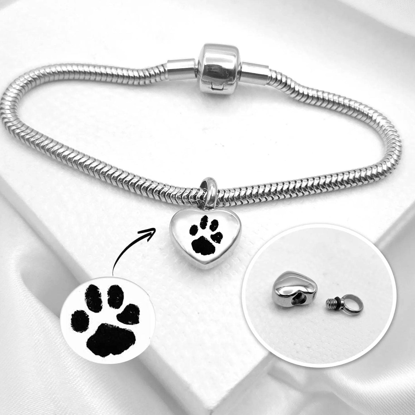 Silver bracelet with heart-shaped paw print charm on a white background