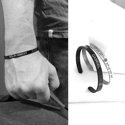 Black bracelet with engraved text worn on a wrist, close-up view.