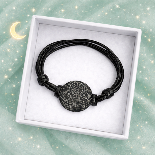 Black cord bracelet with adjustable knots displayed inside a white jewelry gift box, featuring a round engraved star map bracelet. The minimalist keepsake rests on a soft cushion against a mint green background with stars and moon accents. Personalized constellation bracelet, couples gift, “written in the stars” jewelry, meaningful anniversary or long distance relationship keepsake.