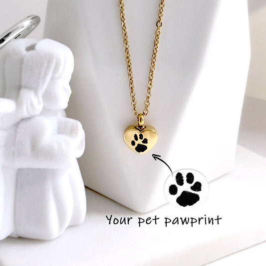 Gold necklace with heart-shaped pawprint pendant on a white background