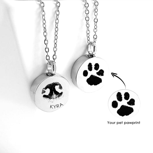 Two silver urn necklaces with paw prints and the name 'Kyra' on a white background