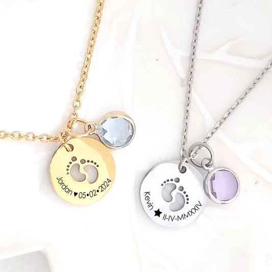 Two necklaces with engraved footprints and birthstones on a white background