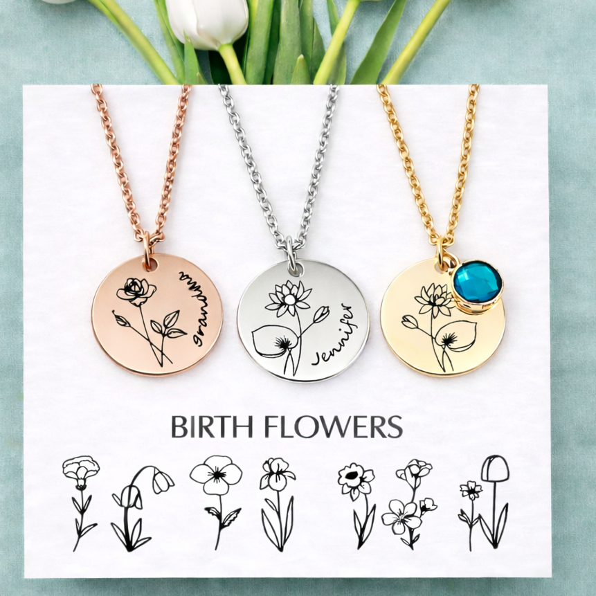 Three necklaces with floral designs on a card with birth flower illustrations, surrounded by white tulips.
