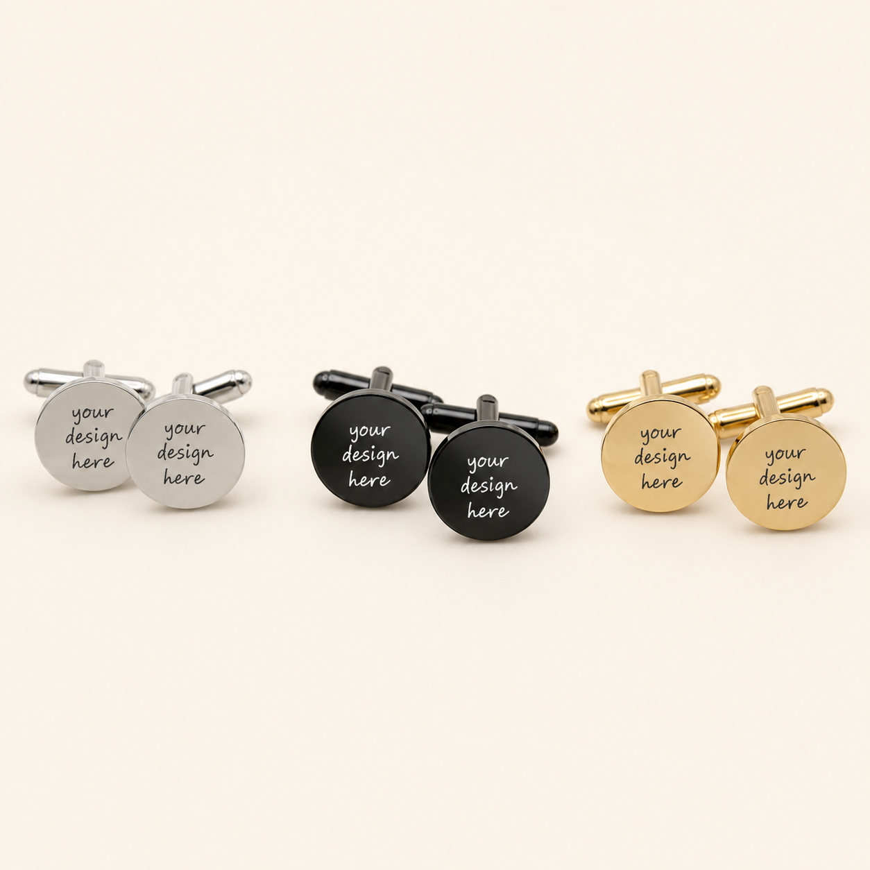 Three pairs of round stainless steel cufflinks displayed in polished silver, glossy black, and gold finishes. Each circular face features the sample engraving “your design here,” showing where a personalized name, message, symbol, or image can be added.