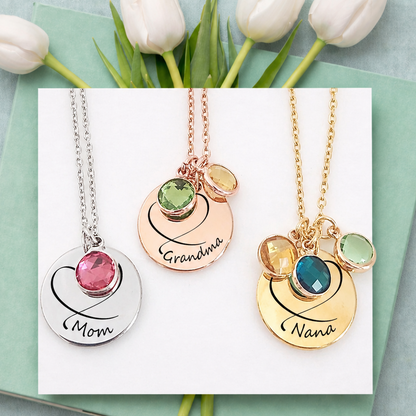 Three necklaces with engraved names on a card with tulips in the background