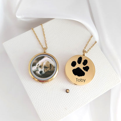 Pet paw print memorial locket with photos and urn for ashes.