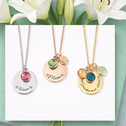 Three necklaces with engraved names on a card with white lilies.