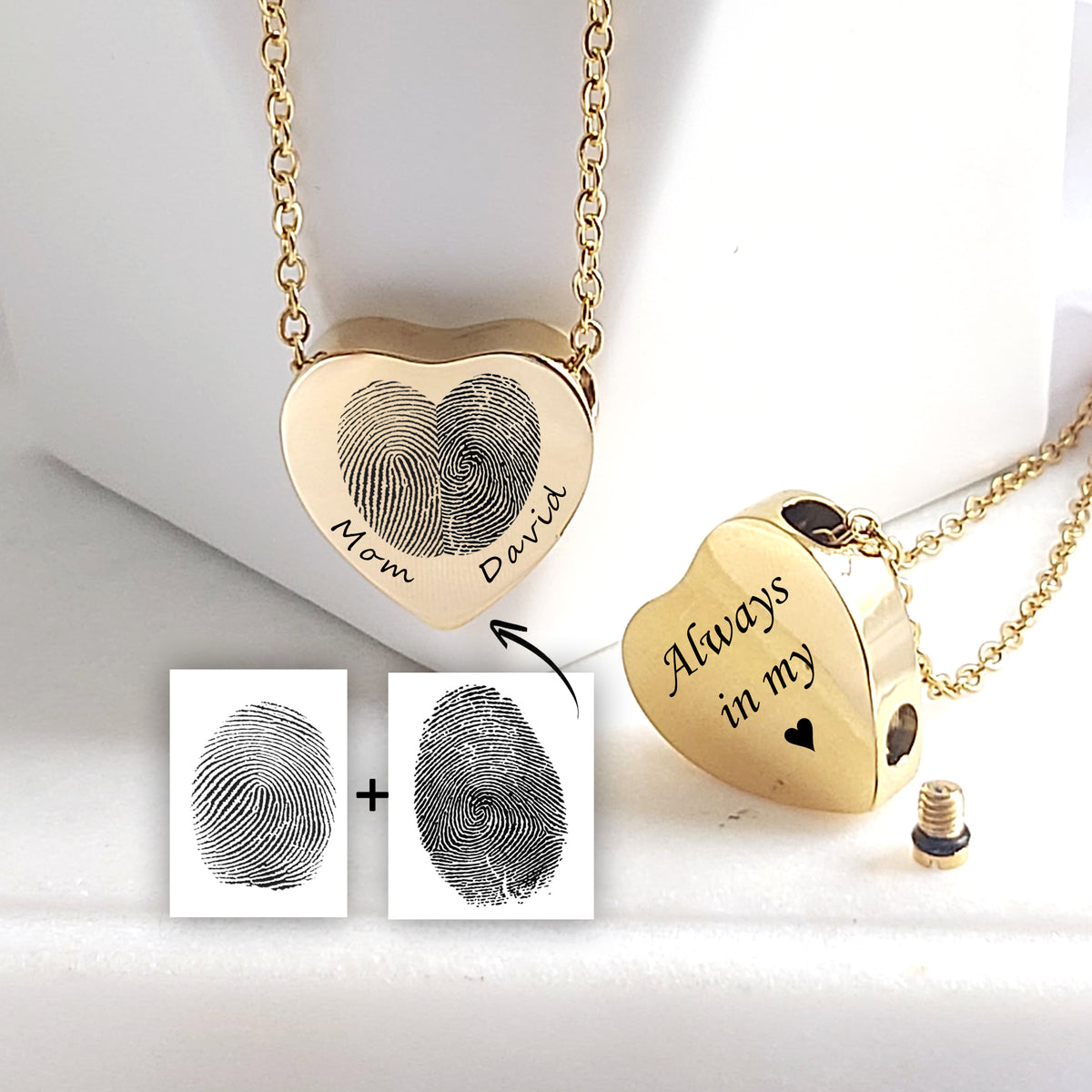 Two gold heart-shaped urn necklaces with matching chains displayed on a white surface. One pendant is engraved with two fingerprints joined into a heart and the names “Mom” and “David.” The other is engraved with “Always in my” and a heart symbol. Two fingerprint reference images and a removable threaded screw are also visible.