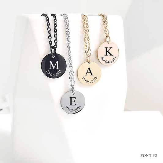 Four necklaces with engraved letters and dates on a white background