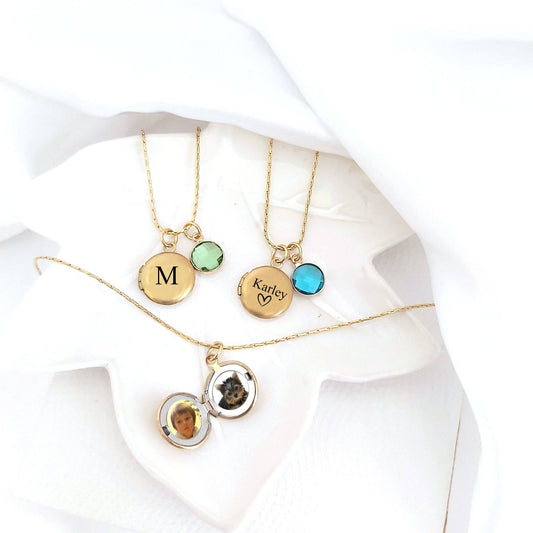 Gold necklaces with round pendants on a white fabric background