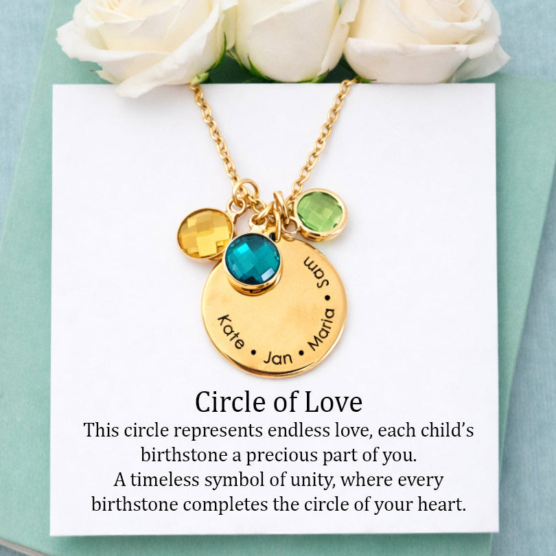 Gold necklace with birthstone charms on a card with white roses on a light blue background