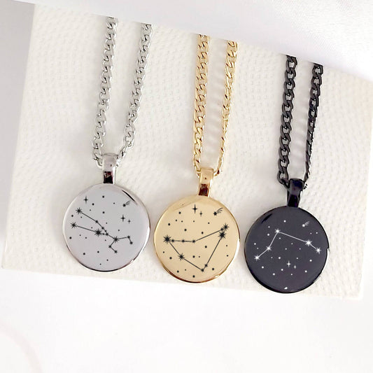 Three necklaces with star constellation pendants on a textured white surface