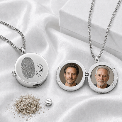Polished silver-tone round urn locket necklace shown open and closed on white fabric. The closed locket is engraved with a large fingerprint and the name “Dad.” The open locket displays two circular portrait photos. A silver chain, small screw closure, filling tool, and white gift box are also visible.