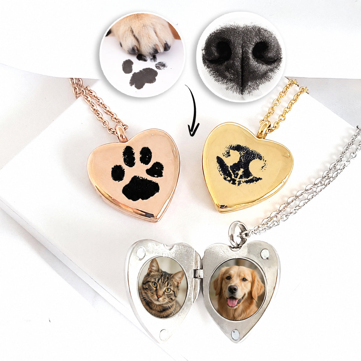 Rose gold and gold heart-shaped lockets on matching chains, engraved in black with a pet paw print and nose print. An open silver heart locket displays photographs of a cat and golden dog. Circular paw and dog nose reference images appear above on a white background.