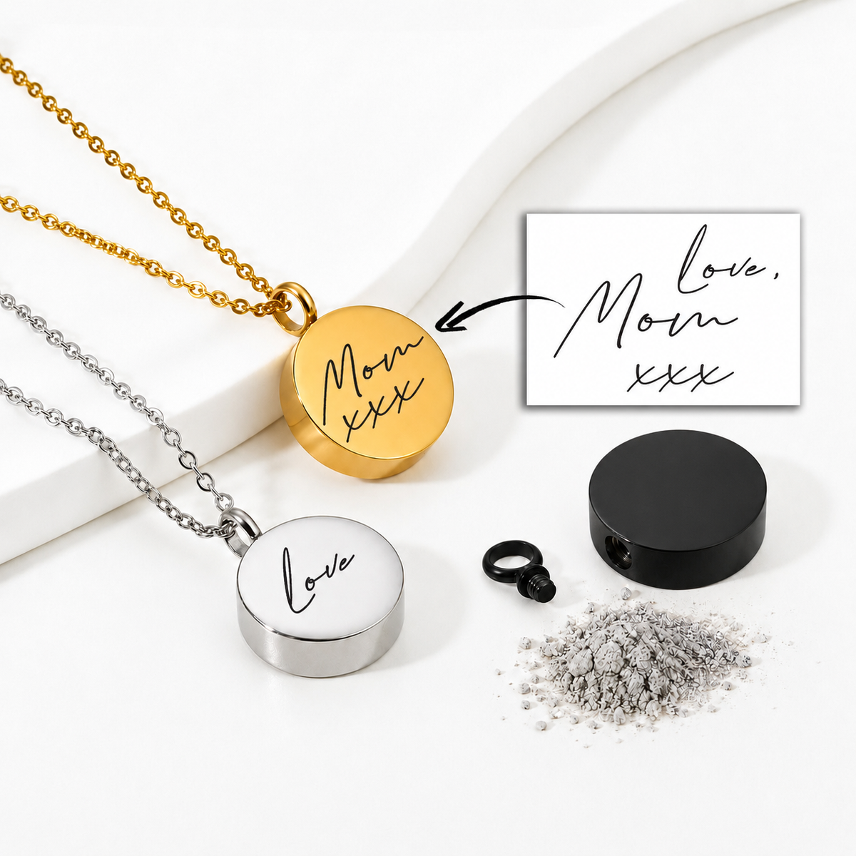 Round memorial urn necklaces displayed in gold, silver and black finishes on a white background. The gold pendant is engraved with “Mom xxx,” and the silver pendant reads “Love” in handwritten script. A handwritten “Love, Mom xxx” reference, black screw closure and symbolic ashes are also shown.